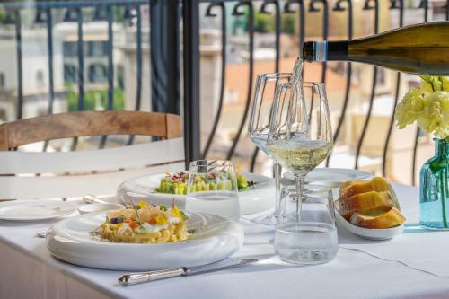 a table with a bottle of wine and plates of food at Albergo Miramare Positano in Positano
