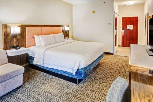 Pokój hotelowy z dużym łóżkiem i krzesłem w obiekcie Hampton Inn Van Buren w mieście Van Buren