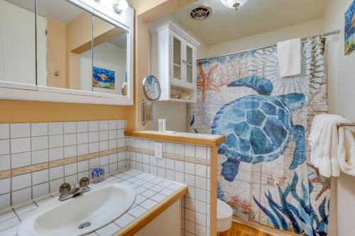 a bathroom with a turtle shower curtain and a sink at Kaunakakai Condo with Private Lanai and Ocean Views! in Kaunakakai