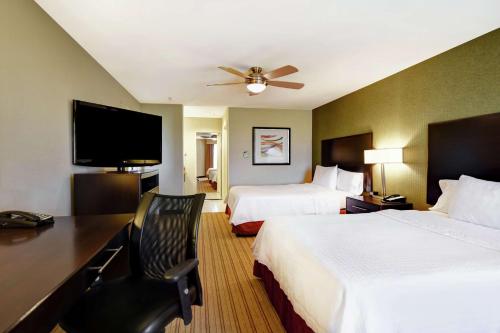 a hotel room with two beds and a flat screen tv at Homewood Suites by Hilton Fort Worth West at Cityview in Fort Worth