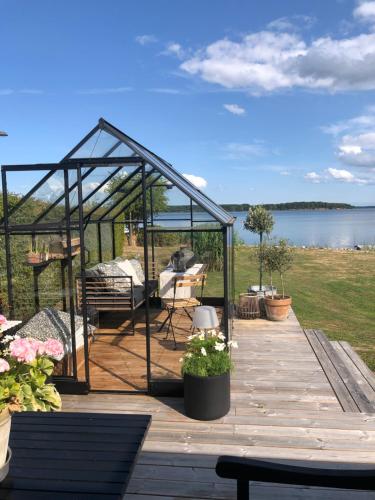 ein Gewächshaus auf einer Terrasse mit Blick auf das Wasser in der Unterkunft Hideaway Engvej in Guldborg