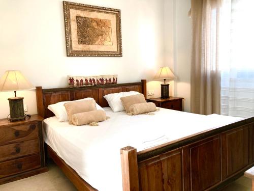 ein Schlafzimmer mit einem großen Bett mit weißer Bettwäsche und zwei Lampen in der Unterkunft Golf&sea views townhouse. in San Roque