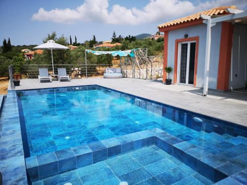 a swimming pool in a villa with a house at Fiora Villas in Trapezaki