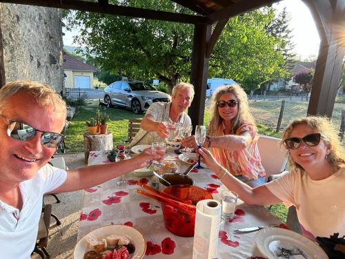 a group of people sitting around a table with wine glasses at Gite une belle Histoire in Voisey