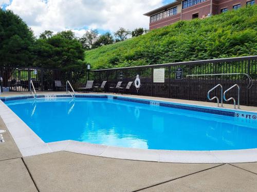 a large blue swimming pool in front of a building at Hampton Inn Greensburg in Greensburg