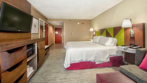a hotel room with a bed and a flat screen tv at Hampton Inn Gaffney in Gaffney