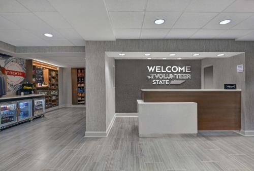 a lobby of a convenience store with a welcome sign at Hampton Inn Gallatin in Gallatin
