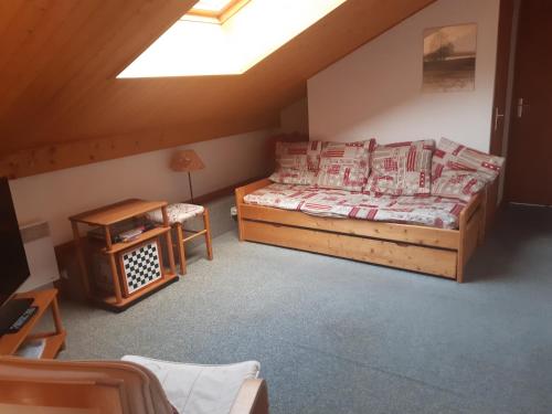 1 dormitorio con cama y mesa en el ático en Les Perthuis - Portes du Soleil, en Châtel