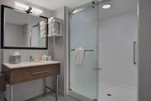 a bathroom with a glass shower and a sink at Hampton Inn Gallatin in Gallatin