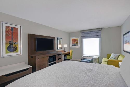 a hotel room with a bed and a flat screen tv at Hampton Inn Gallatin in Gallatin