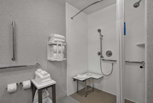 a white bathroom with a shower and a sink at Hampton Inn Gallatin in Gallatin