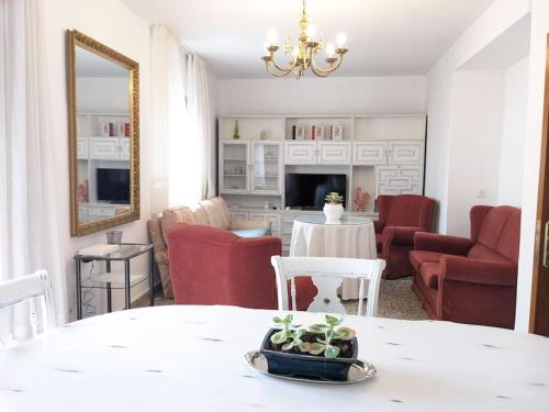 sala de estar con mesa y sillas rojas en Luminosa casa familiar céntrica, en Marbella