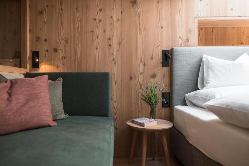 a bedroom with a couch and a bed and a table at Sunnseit Apartment 6 in Ultimo