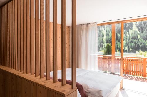 a bedroom with a bed and a large window at Sunnseit Apartment 6 in Ultimo