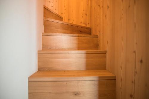a wooden staircase with wooden steps in a room at Sunnseit Apartment 6 in Ultimo