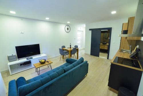 een woonkamer met een blauwe bank en een tafel bij Apartment Sara Sinj in Sinj