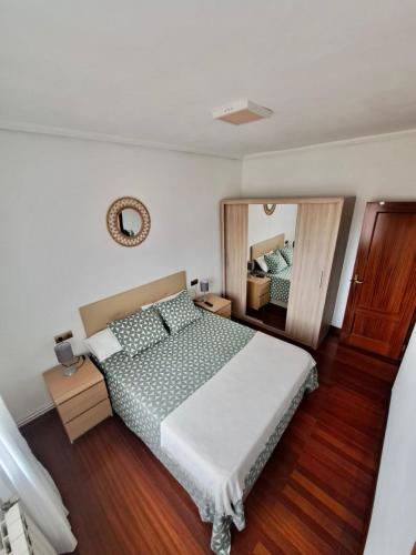 Un dormitorio con una cama y un espejo grande. en Apartamento luminoso Santander, en Santander
