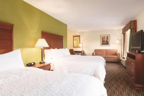 a hotel room with two beds and a flat screen tv at Hampton Inn & Suites Greenfield in Greenfield