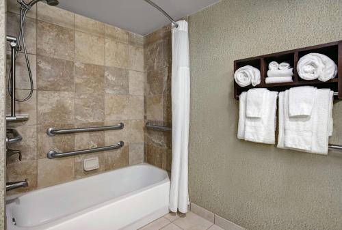 ein Bad mit einer Badewanne und einer Dusche mit Handtüchern in der Unterkunft Hampton Inn Greenville/Woodruff Road in Greenville