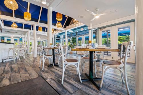 a restaurant with tables and chairs and windows at Park Shore Resort in Naples