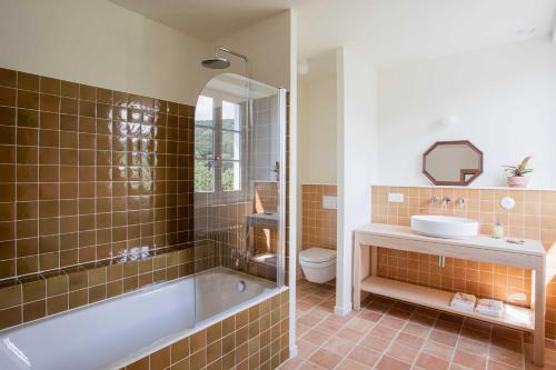 a bathroom with a tub and a sink and a toilet at Maison Gamboia, chambres et table d'hôtes au calme avec jardin in Hasparren