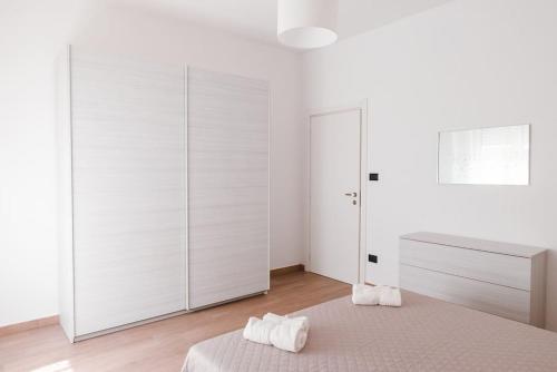 um quarto branco com uma cama e uma cómoda em Casa Rosarè em Montesilvano