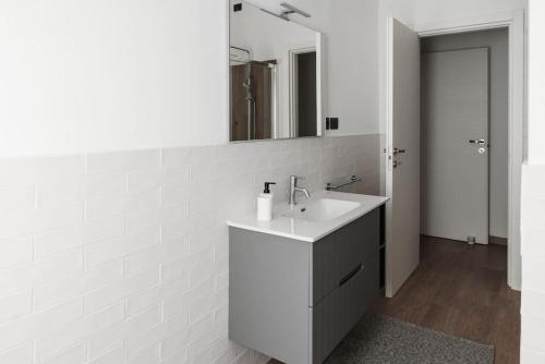 uma casa de banho branca com um lavatório e um espelho em Casa Rosarè em Montesilvano