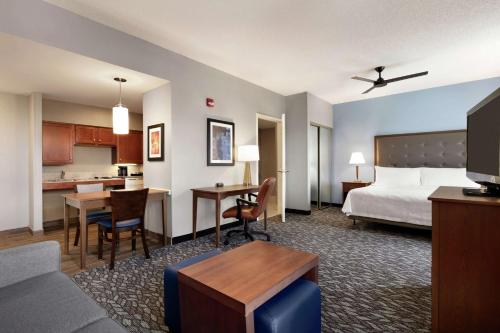 a hotel room with a bed and a living room at Homewood Suites by Hilton Harrisburg East-Hershey Area in Harrisburg