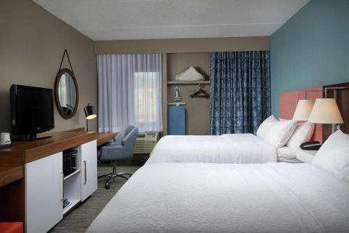 a hotel room with two beds and a television at Hampton Inn Hanover in Hanover