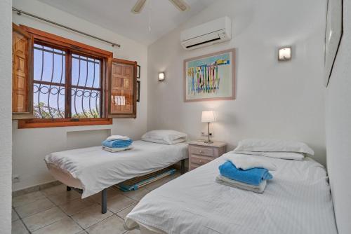 two twin beds in a room with a window at Casa Bonita in Salobreña