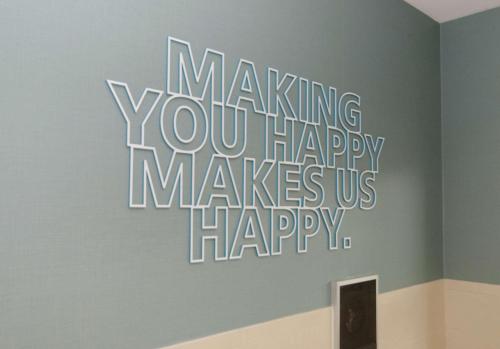 a wall with a sign that says making you happy makes us happy at Hampton Inn Hickory in Hickory