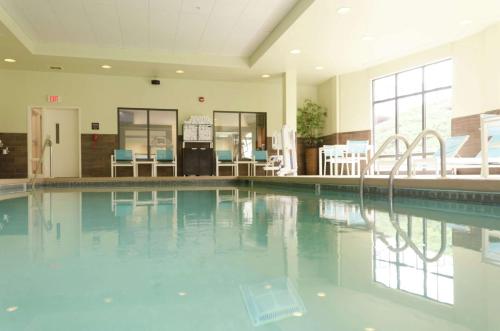 a swimming pool with blue chairs in a building at Hampton Inn Hickory in Hickory