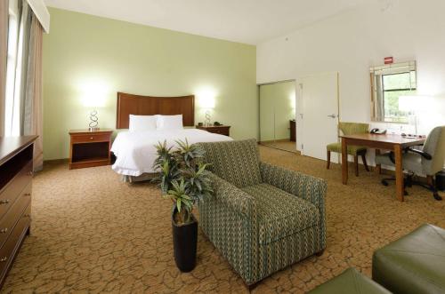 a hotel room with a bed and a chair and a desk at Hampton Inn Hickory in Hickory