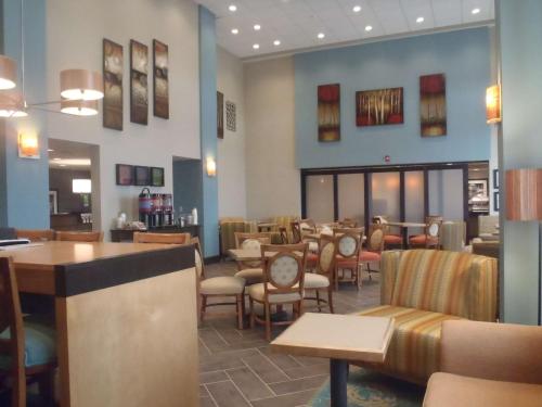 a restaurant with chairs and tables and a bar at Hampton Inn & Suites Wiggins in Wiggins