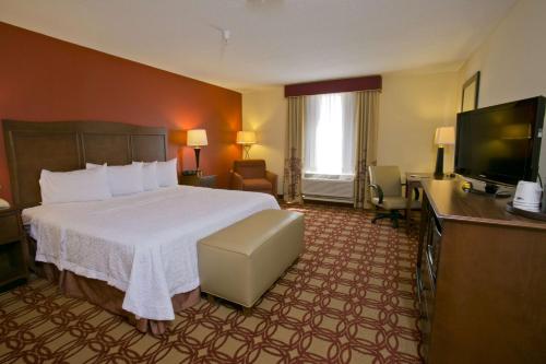 a hotel room with a bed and a flat screen tv at Hampton Inn & Suites Wiggins in Wiggins