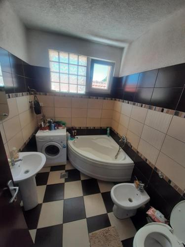 a bathroom with two toilets and a tub and a sink at City Park Rooms in Vranje