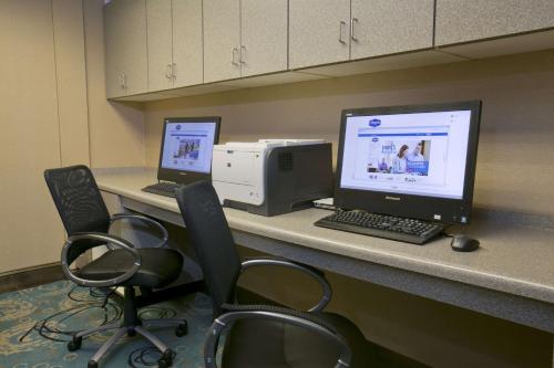 a desk with two computers and a printer and chairs at Hampton Inn & Suites Wiggins in Wiggins