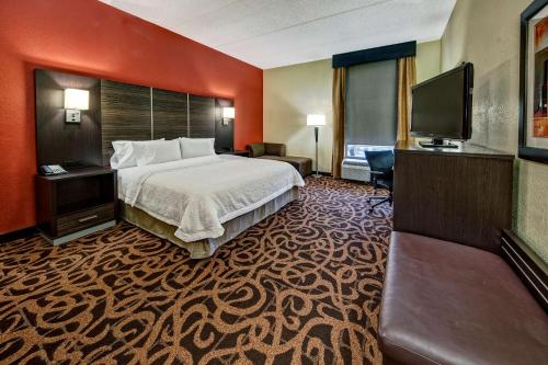 a hotel room with a bed and a flat screen tv at Hampton Inn Houston Baytown in Baytown