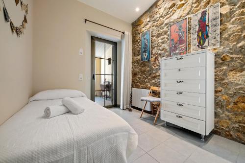 a bedroom with a bed and a stone wall at Hauzify I Casa Palou in Palamós