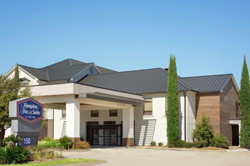 a large white building with a sign in front of it at Hampton Inn & Suites Houston-Cypress Station in Westfield
