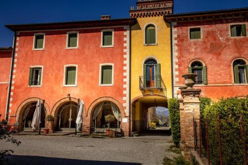 a large red and yellow building with an entry way at Villa Clementina - Prosecco Country Hotel in San Pietro di Feletto