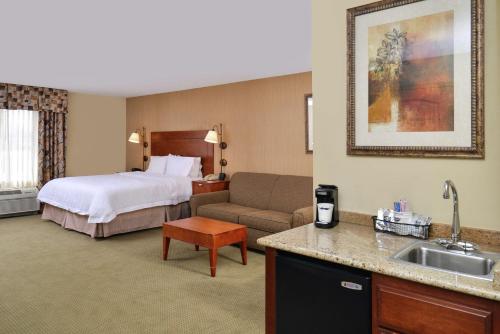 een hotelkamer met een bed en een bank bij Hampton Inn Harrison in Harrison