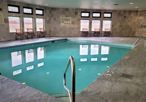 a swimming pool with chairs in a building at Hampton Inn Hays-North of I-70 in Hays