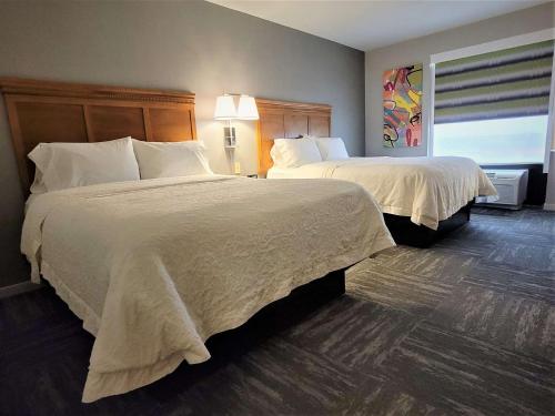 a hotel room with two beds and a window at Hampton Inn Hays-North of I-70 in Hays