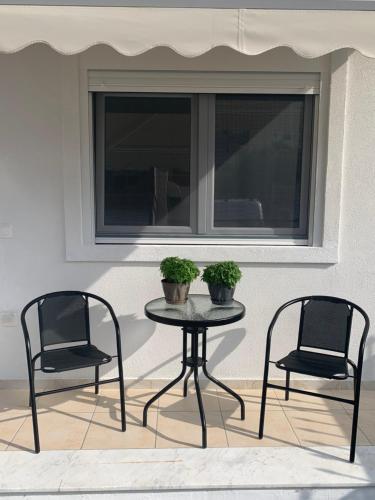 two chairs and a table in front of a window at SK Apartment in Neoi Epivates