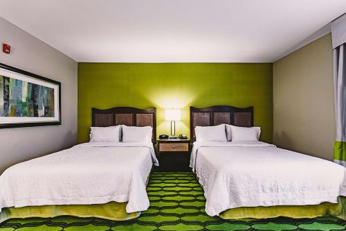 two beds in a room with green walls at Hampton Inn Niagara Falls/ Blvd in Niagara Falls