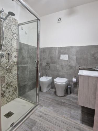 a bathroom with a shower and a toilet and a sink at Hotel Porta Marmorea in Gubbio