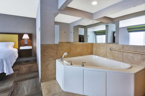 a bath tub in a room with a bed at Hampton Inn Idaho Falls in Idaho Falls