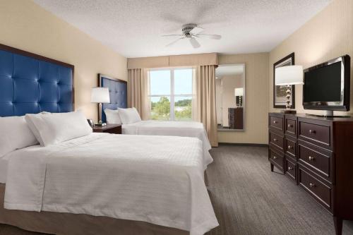 a hotel room with two beds and a flat screen tv at Homewood Suites by Hilton Wilmington-Brandywine Valley in Talleyville