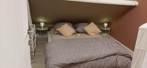 a bedroom with a bed with pillows on it at L'Abri de la Chouette in Frasnes-lez-Anvaing